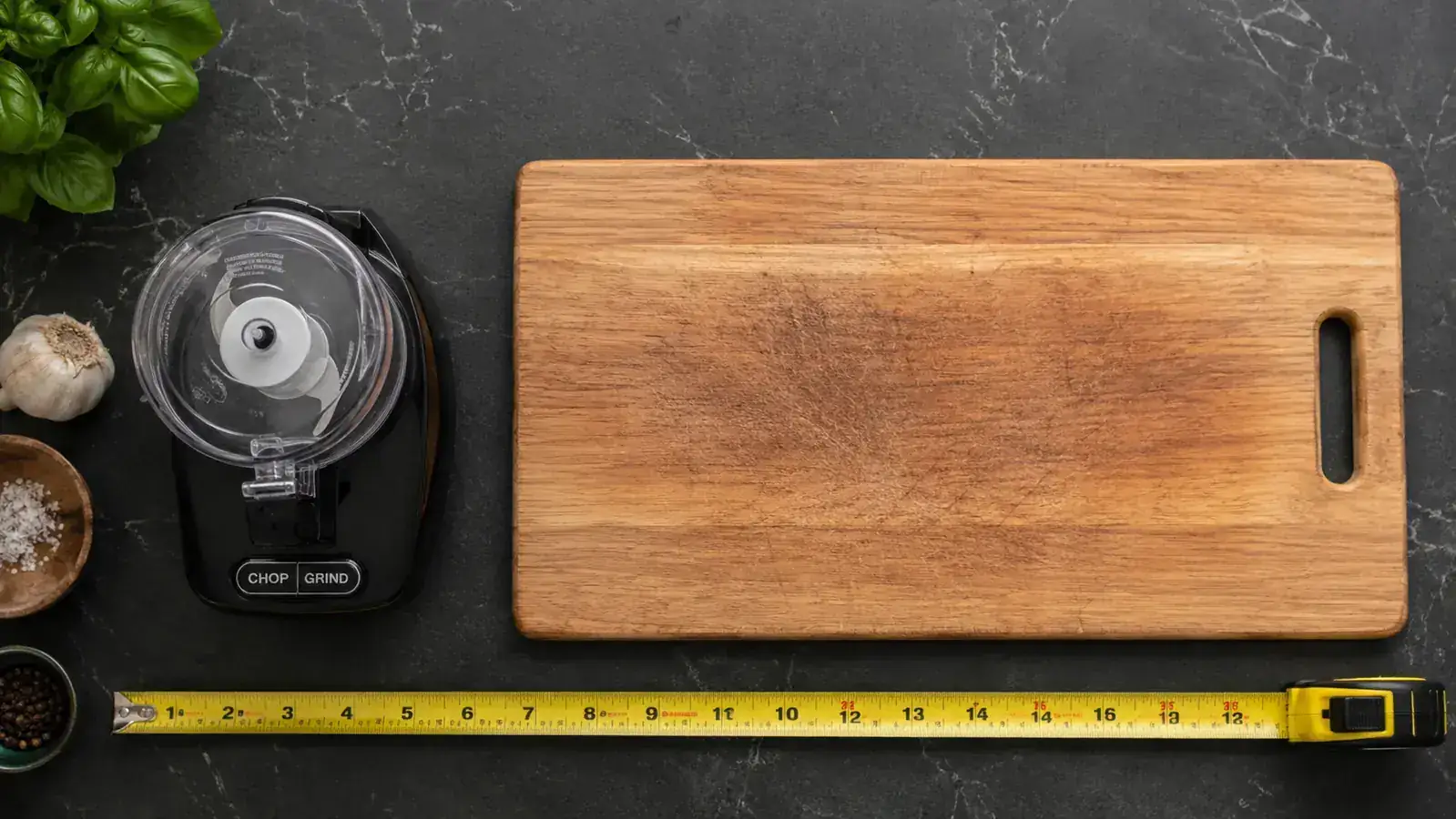 Overhead view of a mini food processor footprint compared to a cutting board, showing the compact 6-inch diameter